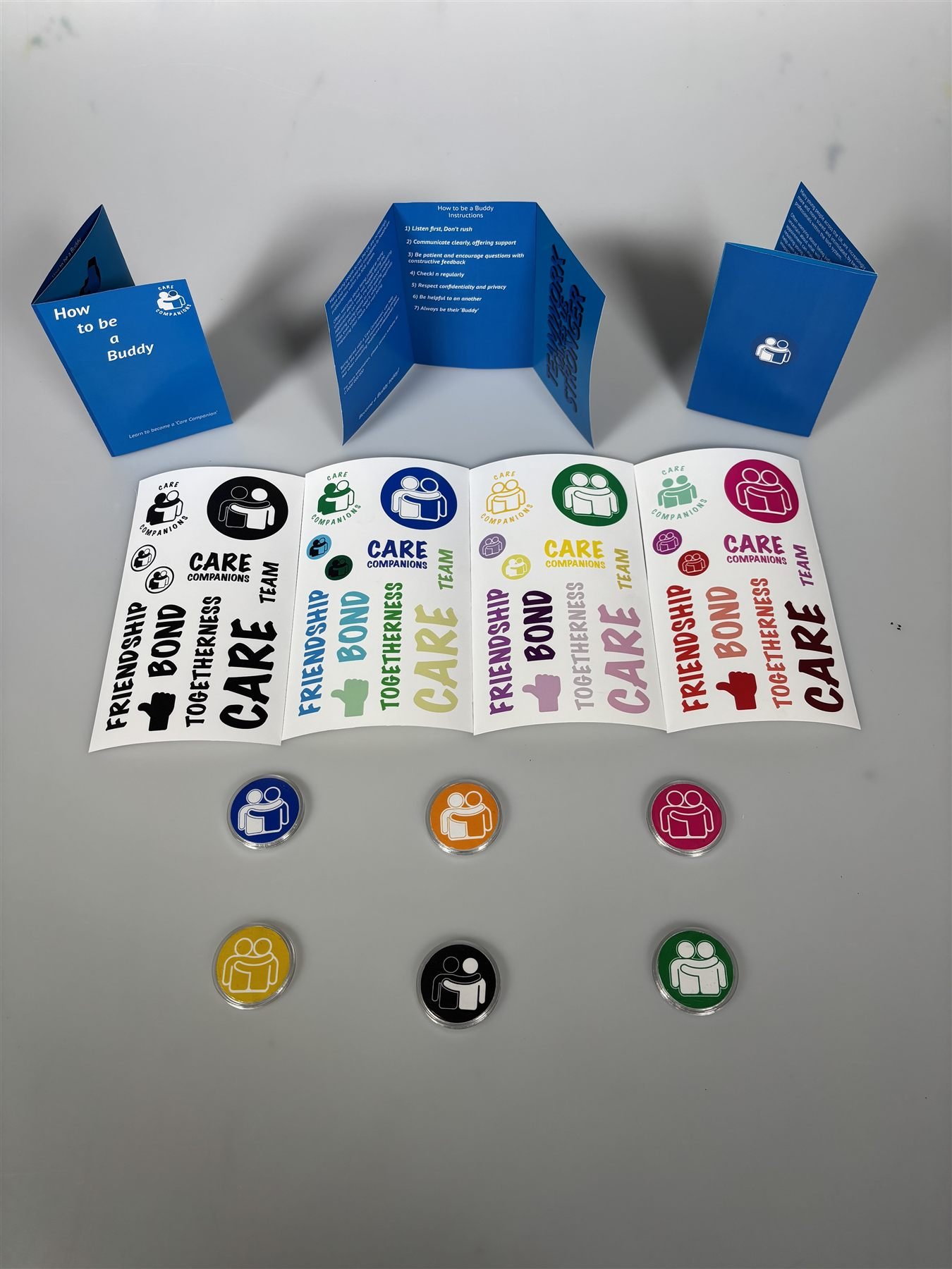 Flat-lay of the Care Companions leaflet, sticker sheets and badges