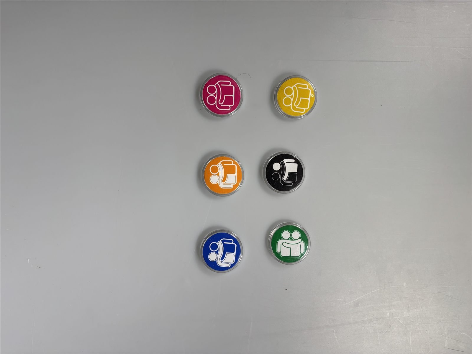 Finished circular badges in six brand colourways