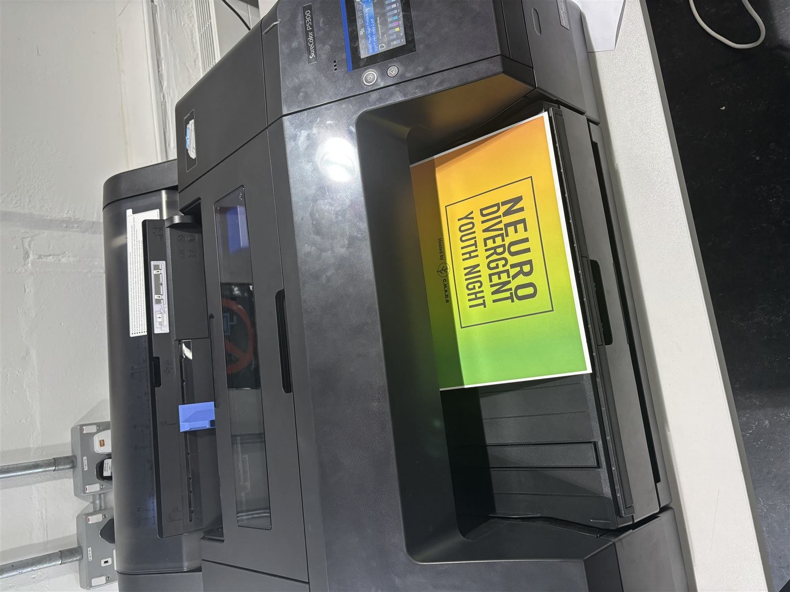 A C.H.A.D.S poster coming off a large-format printer